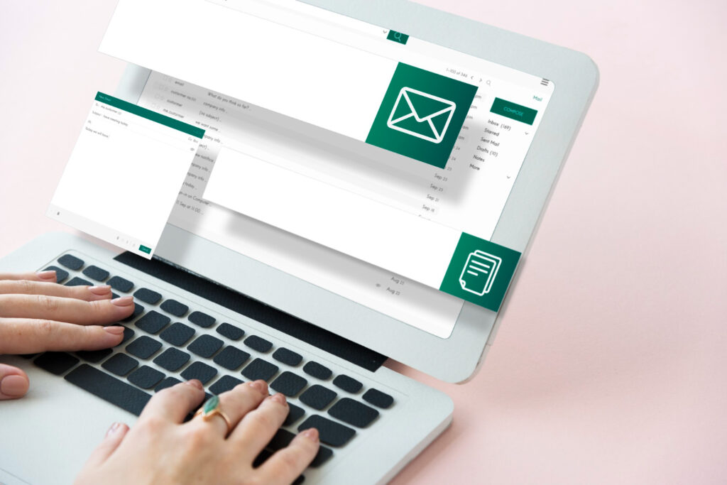 A person typing on a laptop keyboard with an email client interface, compose window, and email icon overlay for email marketing strategy.