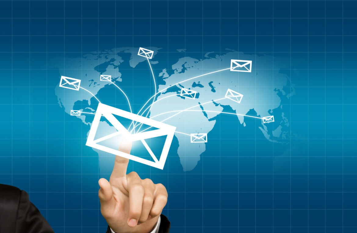 A hand pointing to a digital envelope icon connecting to multiple emails across a world map background, illustrating how email marketing works.